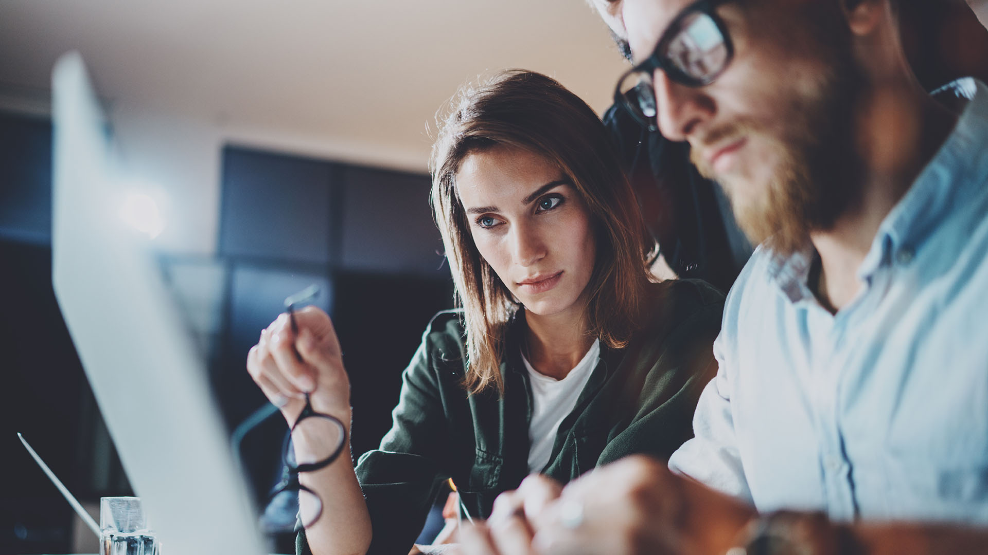 Jonge vrouw en man aan het werk met laptop, kijkend naar het scherm