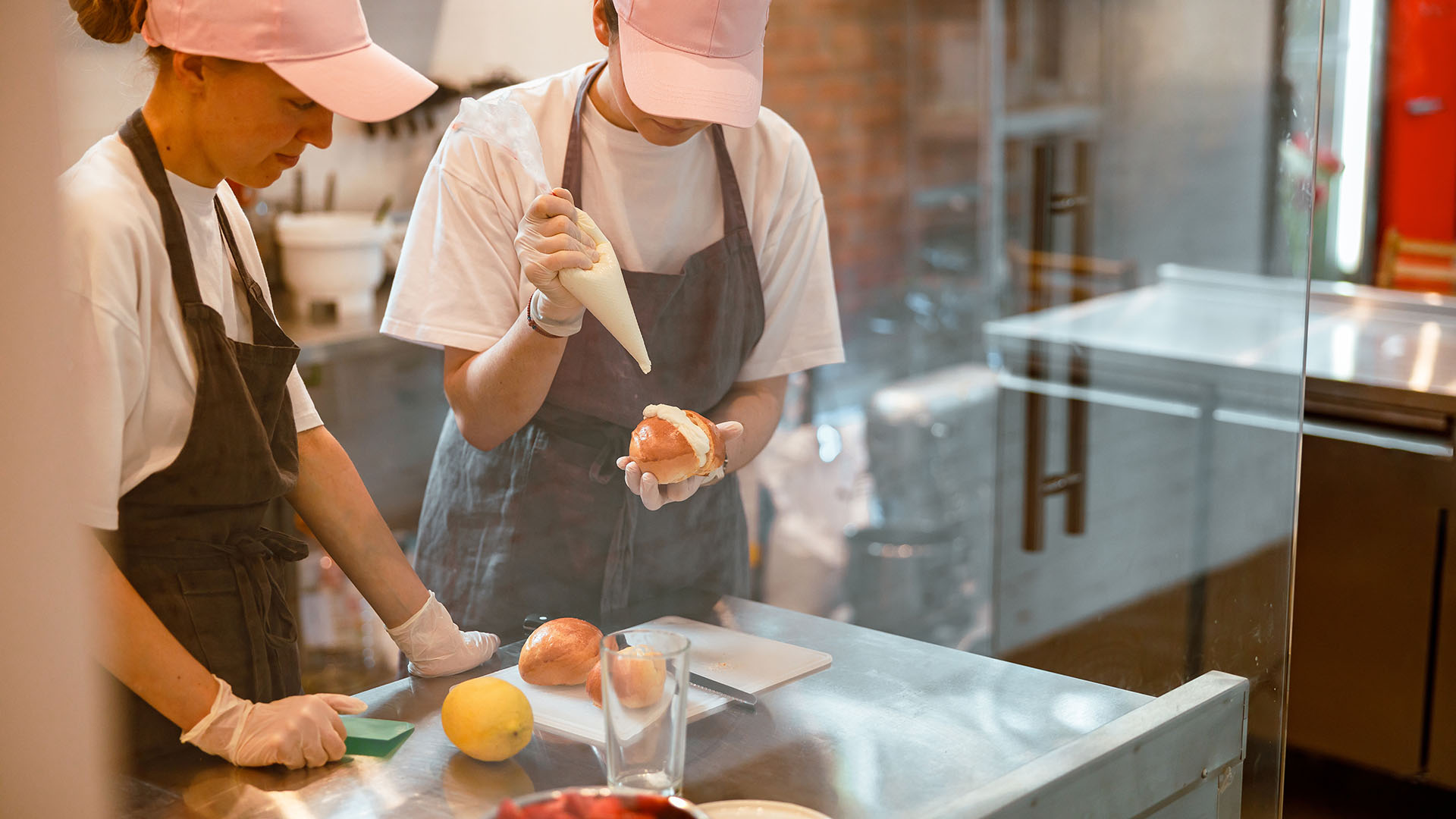 Twee vrouwen in een bakkerij met het maken van puddingbroodjes