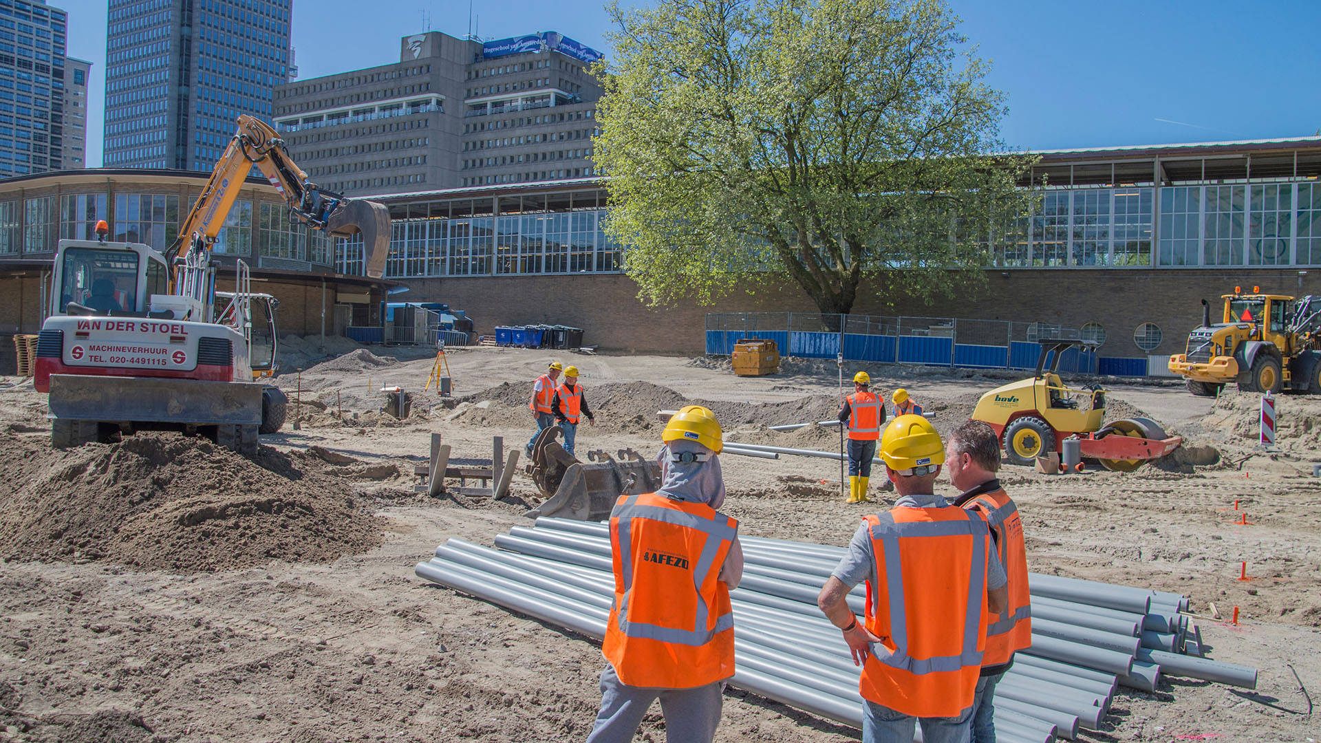 Werknemers, met veiligheidshesje en veiligheidshelm op een bouwplaats