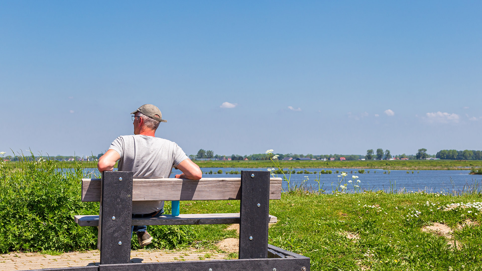 Man op bankje geniet van natuur