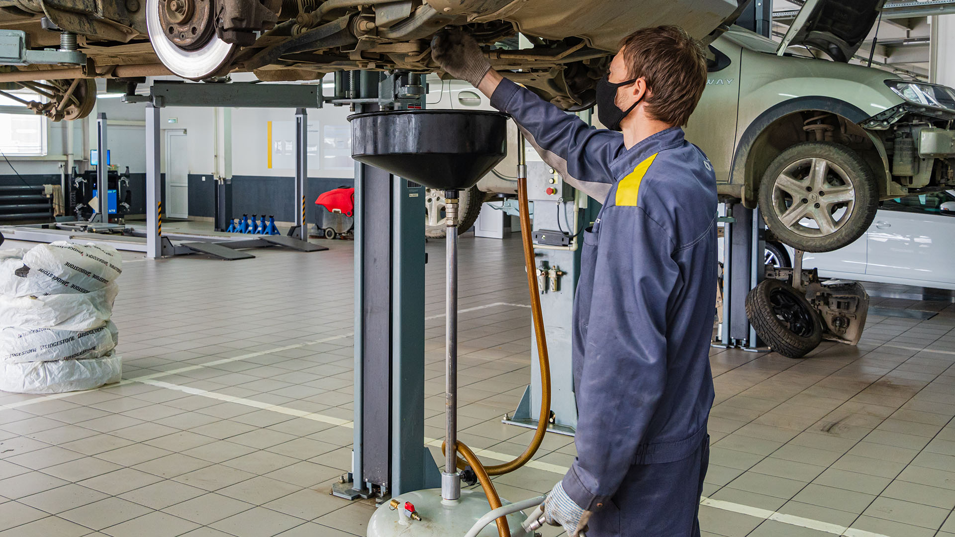 Garagewerker onder auto aan het werk